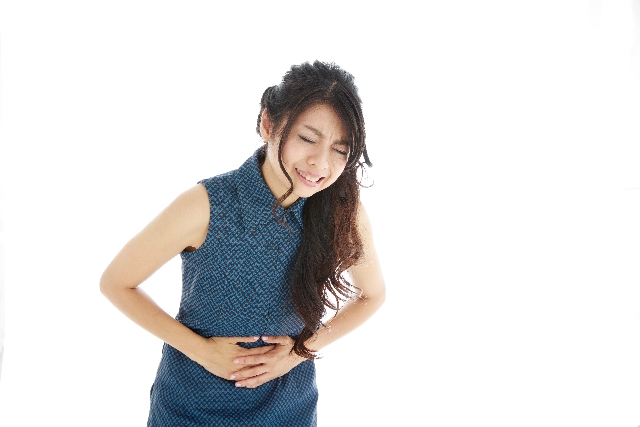 お腹を押さえる女性