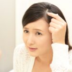 頭皮を指さす女性
