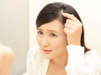 頭皮を指さす女性